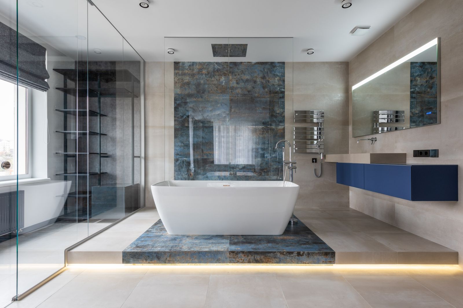 A modern bathroom with navy cabinetry and a freestanding bath