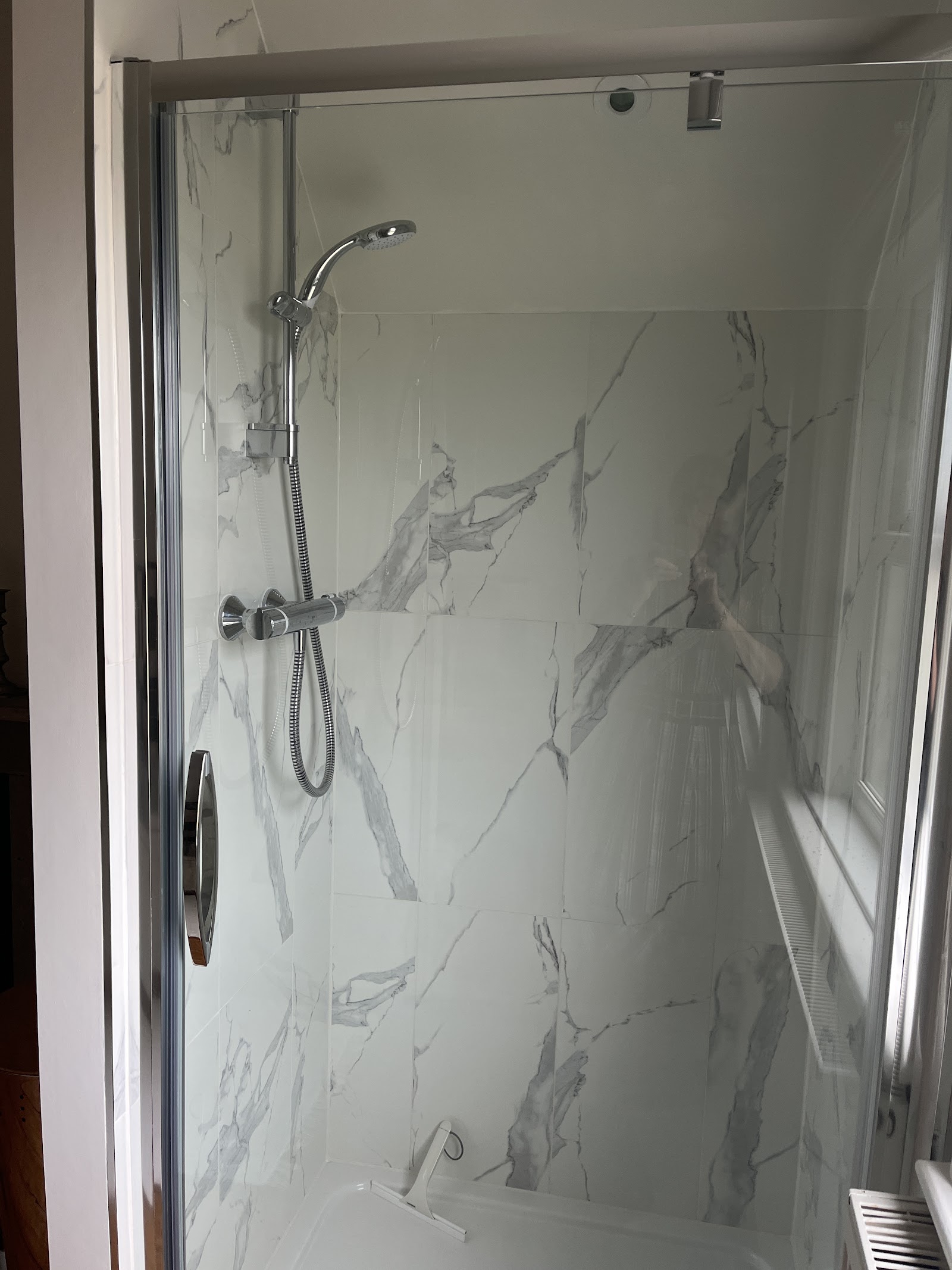 A marble-tiled shower with new thermostatic fittings.